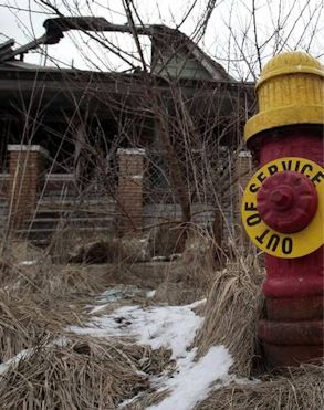 An abandoned house next to an out of service fire hydrant in a Detroit neighborhood.