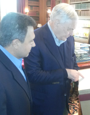 Lord Black and Mr. Fosco examining a book originally owned and signed by Abraham Lincoln.